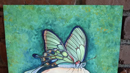 Watercolor and pencil painting of a pale green butterfly on a finger