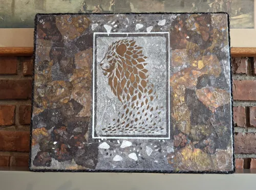 Acrylic artwork featuring a stenciled golden lion profile, framed by a mosaic of dark, earthy tones.